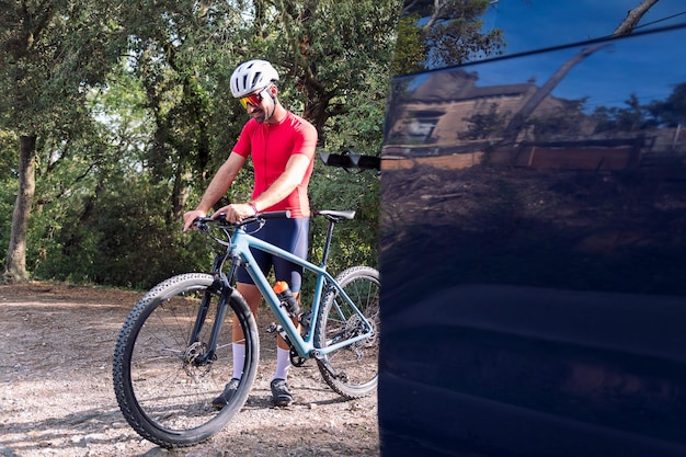 Man kleedt zich naast zijn busje om te gaan fietsen