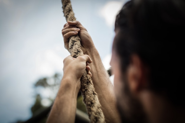 Foto man klimmen een touw tijdens hindernissenparcours