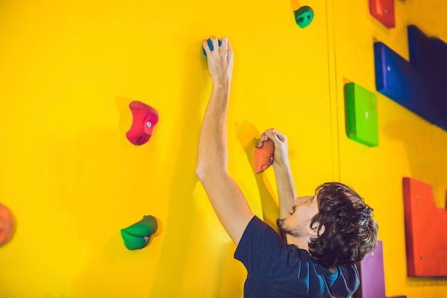 Man klimmer op kunstmatige klimmuur in boulderen sportschool