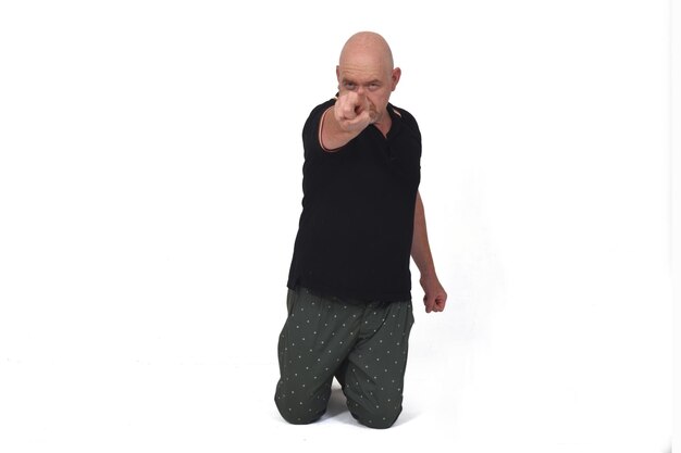 Man on kness pointing on white background