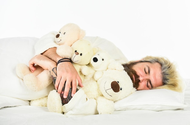 Man knuffel speelgoed ontspannen in bed Goede vibes Denkbeeldige vrienden Streef ernaar om goede slaapgewoonten te oefenen Schattige teddybeer speelgoed Positieve slaapkameromgeving Speels en romantisch Bebaarde hipster speeltje