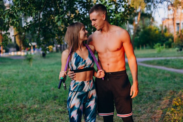 Man knuffelen een meisje. Sportief zich in het park bevinden openlucht en paar die elkaar kijken