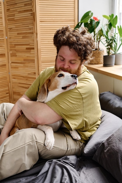 Man knuffelt zijn hond op bed