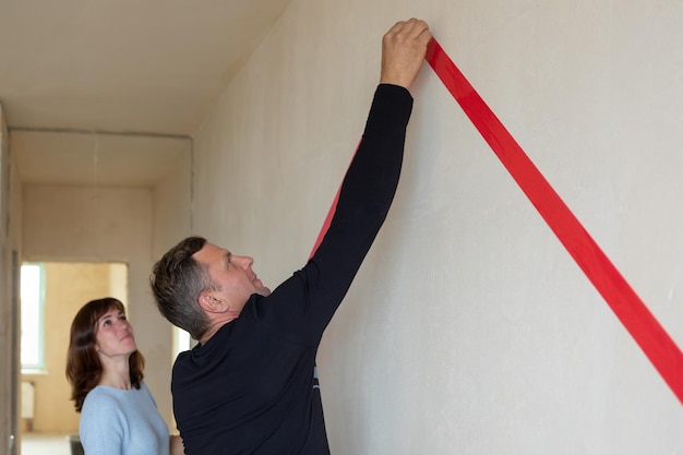 Man knuffelt zijn vrouw Jong stel verhuist naar een nieuw appartement Uitzicht vanaf de zijkant Concept nieuwe huizen nieuw begin