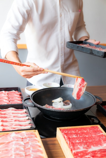 Foto man koken japanse wagyu beef sukiyaki set