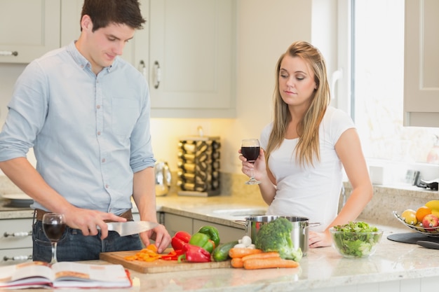 Man koken met vrouw drinken van rode wijn