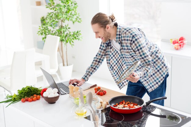 man kookt in de moderne keuken