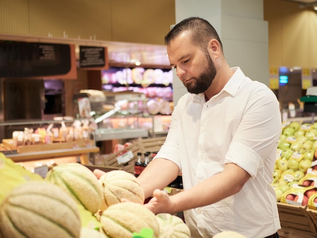 Man koopt groenten en fruit bij supermarkt