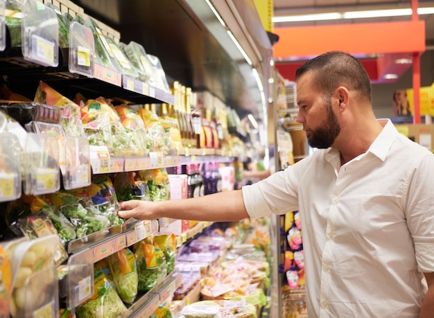 Foto man koopt salade bij supermarkt