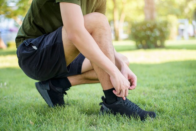 man koppelverkoop de schoenen op het gras