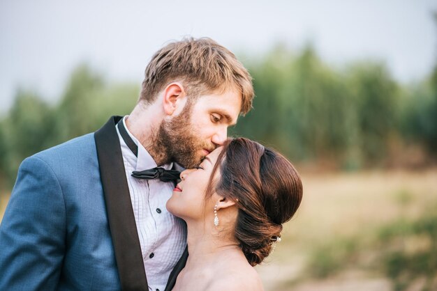 Foto man kust vrouw op het voorhoofd tegen de lucht