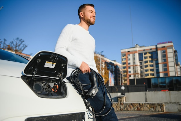 Man laadt een elektrische auto op aan het laadstation