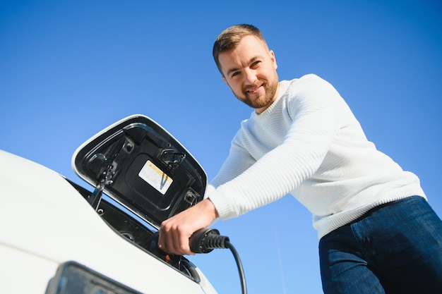 Man laadt een elektrische auto op aan het laadstation