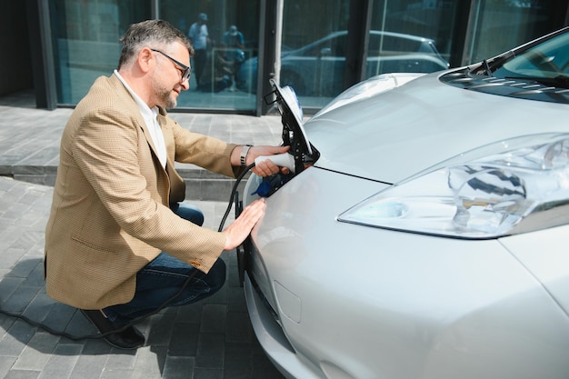 Man laadt een elektrische auto op aan het laadstation