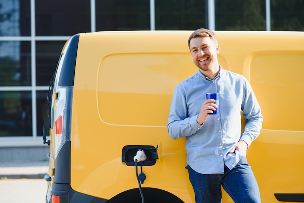 Foto man laadt zijn elektrische auto op bij laadstation