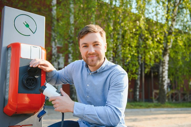 Man laadt zijn elektrische auto op bij laadstation