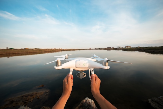 Foto man lanceert drone uit handen in de buurt van rivier