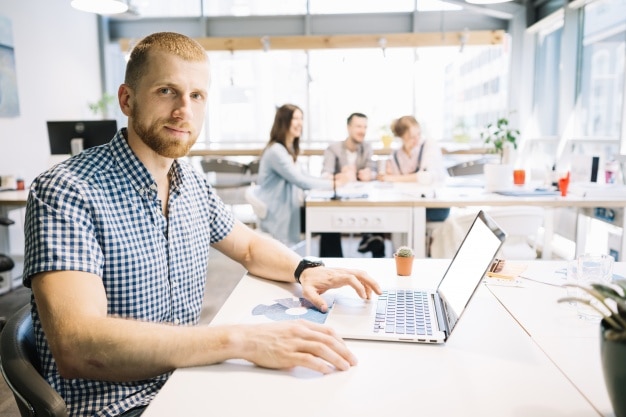 Man at laptop looking at camera