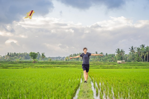 Man launch a kite in a rice field in ubud bali island indonesia