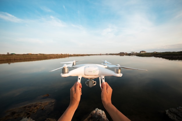 Фото Человек запускает дрон из рук возле реки