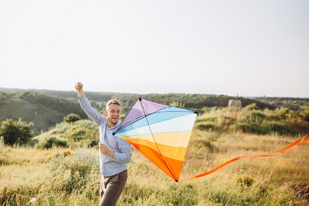 Man launching colorful air kite on the field