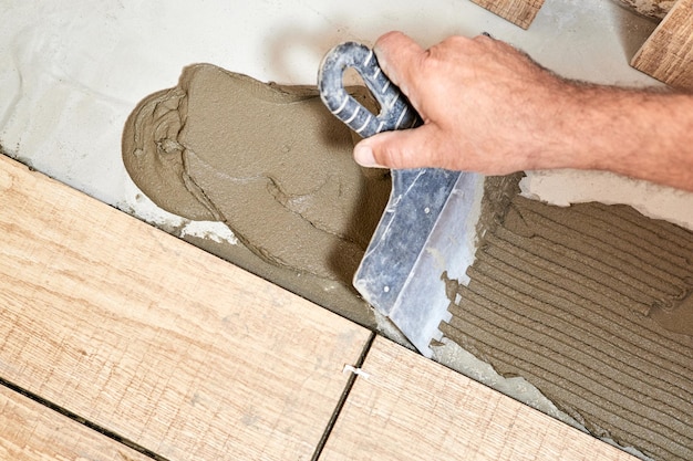 Man laying ceramic floor tiles