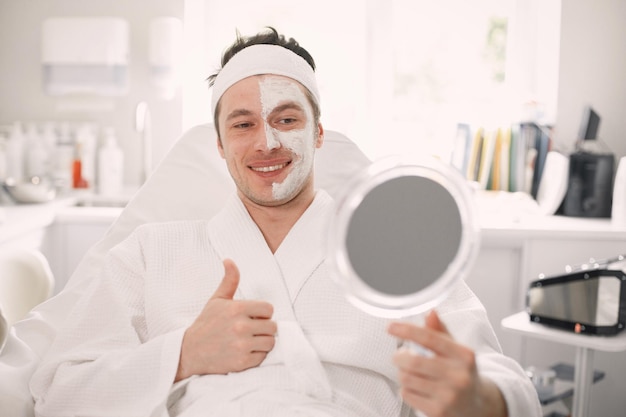 Man laying in cosmetologist cabinet with a mask applied on his face