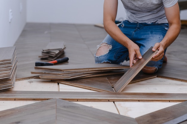 Man laying laminate flooring - closeup on male hands