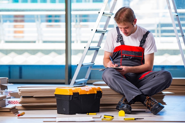 Man laying laminate flooring in construction