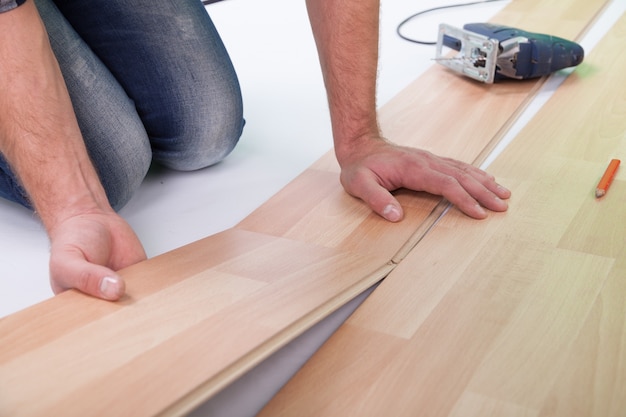 Man laying a new floor planks, close up