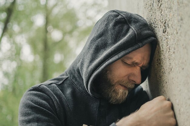 Foto uomo appoggiato al muro