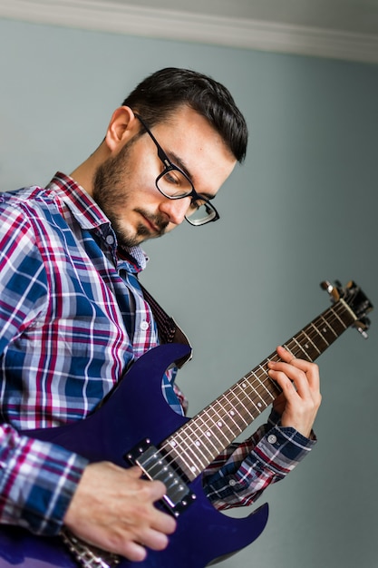 L'uomo impara a suonare la chitarra elettrica a casa