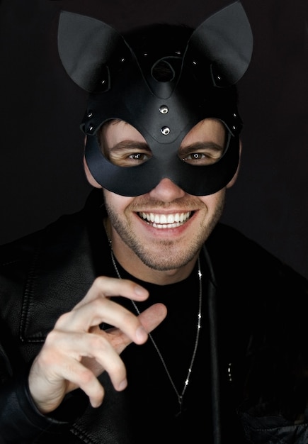 Man in a leather bdsm mask of a cat smiling