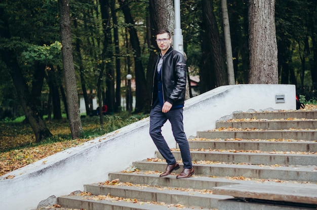 a man in a leather jacket comes down the stairs