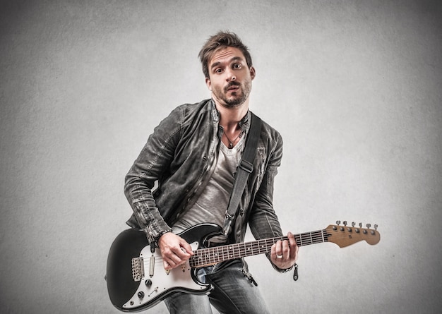 Man in leather jacket playing on a guitar