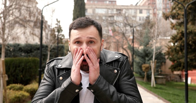 Man in a leather jacket with a red building in the background