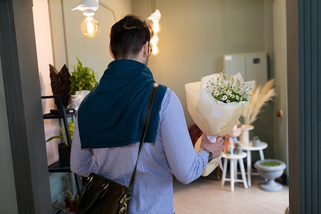 한 남자가 꽃다발을 손에 들고 만족스럽게 꽃가게를 떠나고 있다
