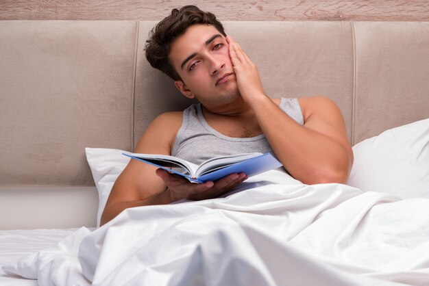 Man leesboek in het bed