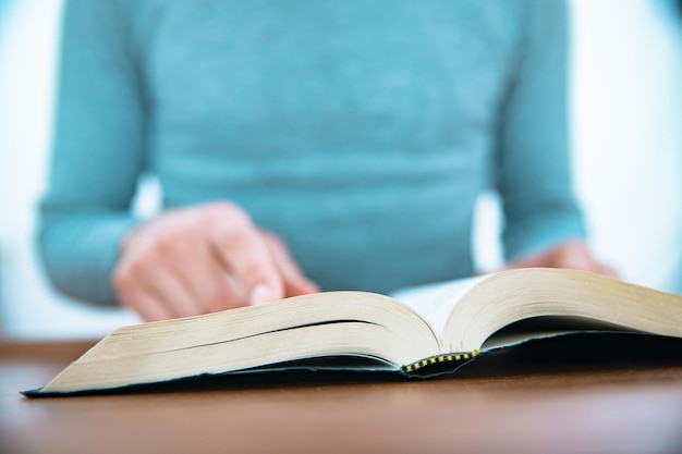 Man leest Bijbel op tafel