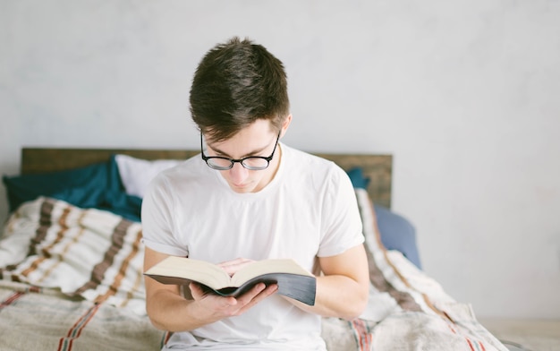Man leest een boek op zijn bed thuis