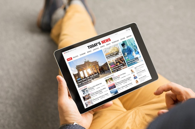 Man leest nieuwswebsite op tablet Alle inhoud is verzonnen