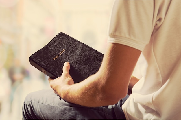 Man leest oud Bijbelboek op achtergrond