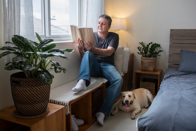 Foto man leest thuis met zijn hondenmaatje