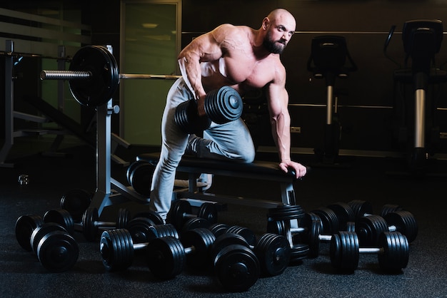 Man leunend op bank en lifting halter