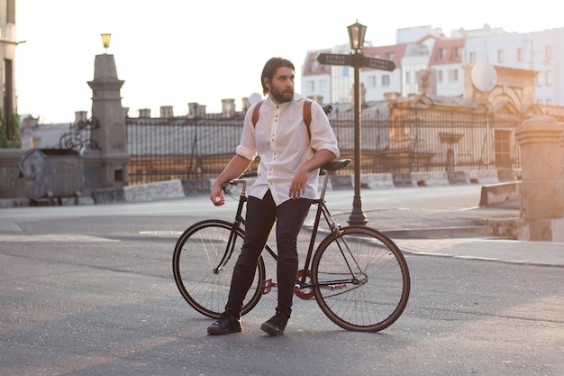 Man leunt op een fiets op een stadsstraat