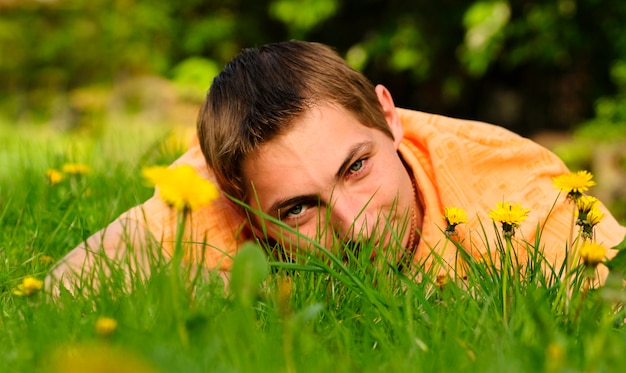 Man lie on the grass. Shallow DOF. Outdoor portrait