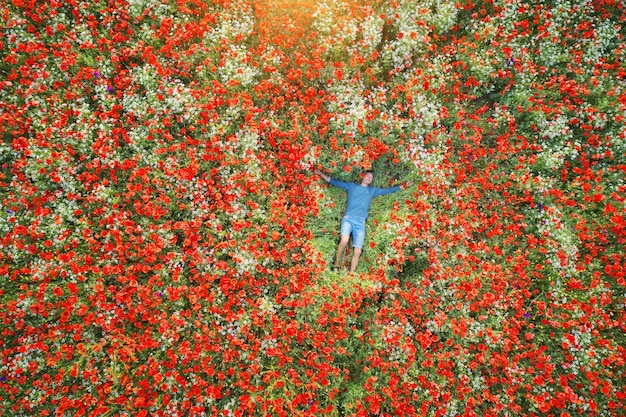 Man lies in a field of poppies