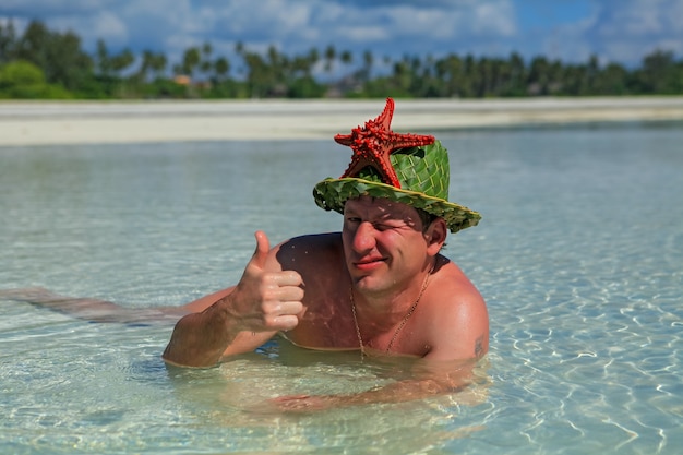 A man lies in the water on the beach