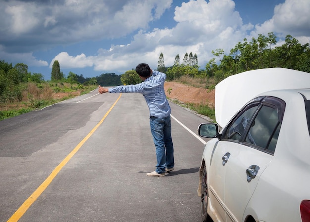 Man liftend door een kapotte auto