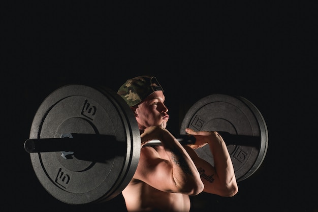 Uomo sollevamento pesi. allenamento uomo muscoloso in palestra facendo esercizi con bilanciere